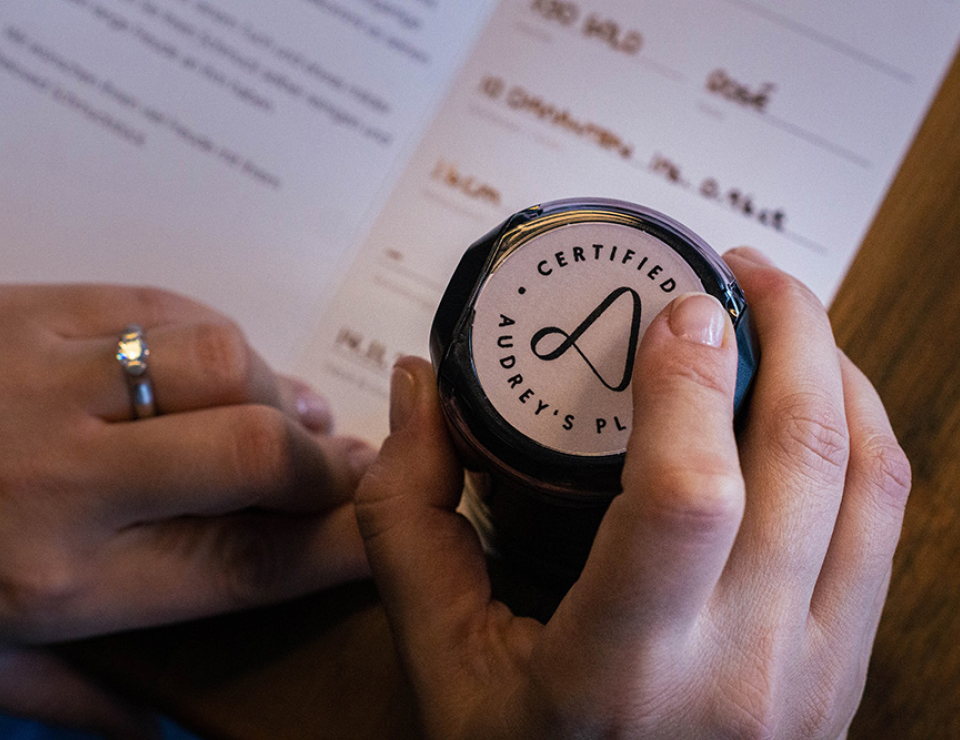 Hand die Qualitätsstempel auf Zertifikat stempelt.