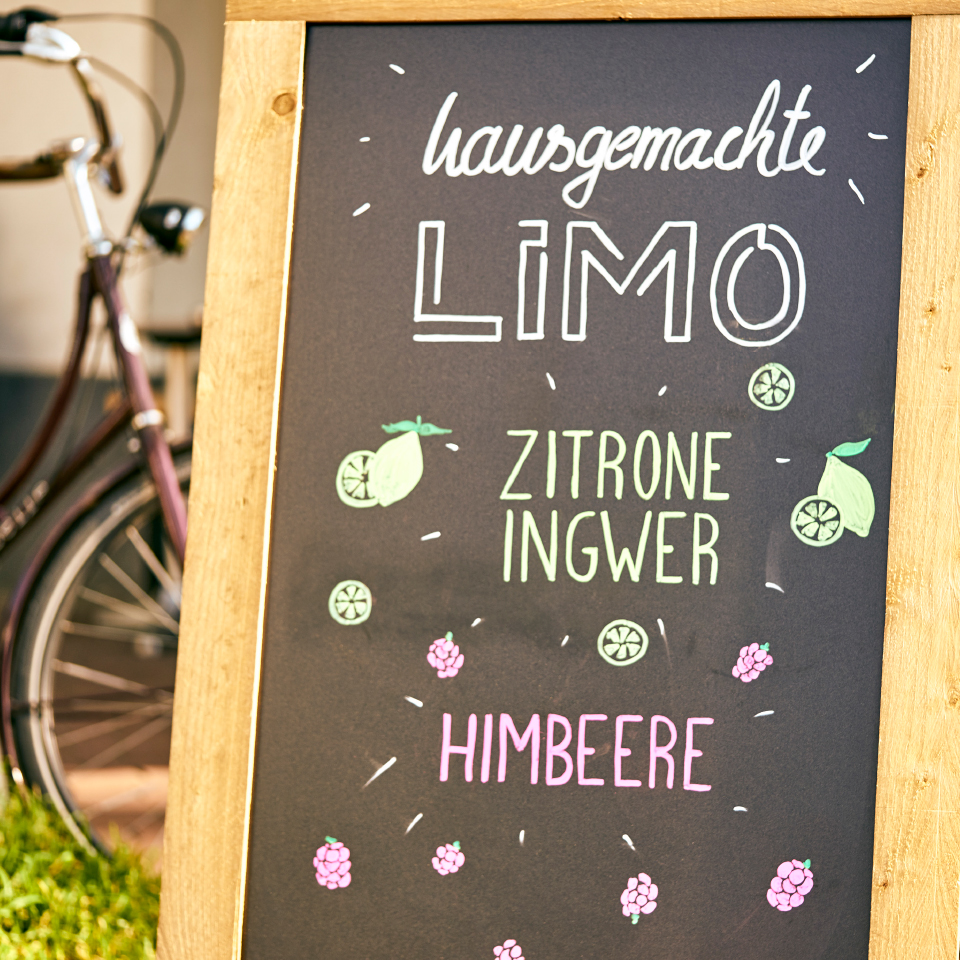 Kreidetafel vor Café mit handgeschriebener Werbung für hausgemachte Limonade.