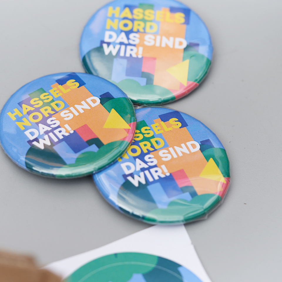 Drei bunte Buttons mit der Aufschrift „Hassels Nord – Das sind wir!“.