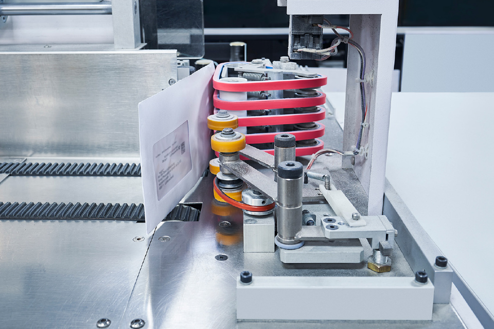 Brief wird maschinell durch eine Sortier- und Transportanlage geführt.