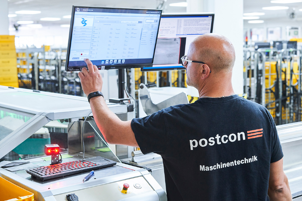 Mitarbeiter von Postcon bedient Sortieranlage.