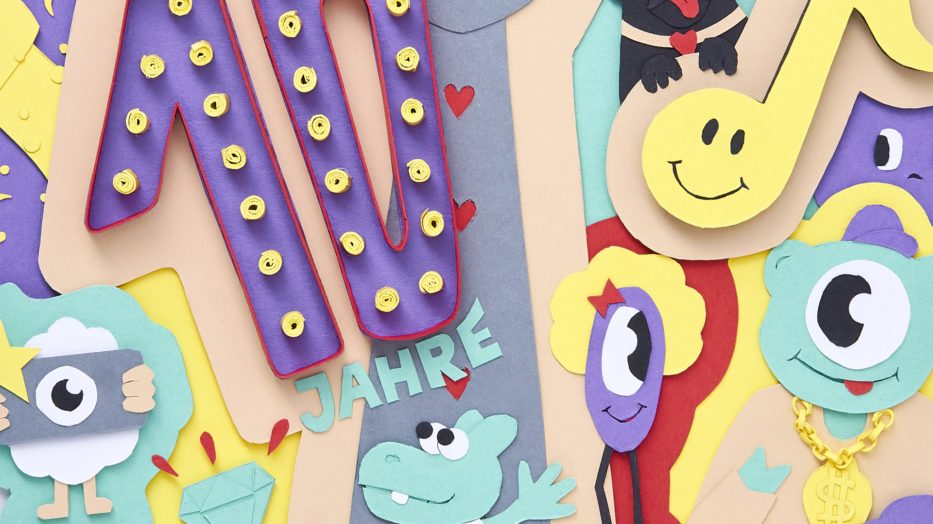 Close-Up von buntem Paper-Artwork mit Figuren, Symbolen und Text „10 Jahre The Dorf“