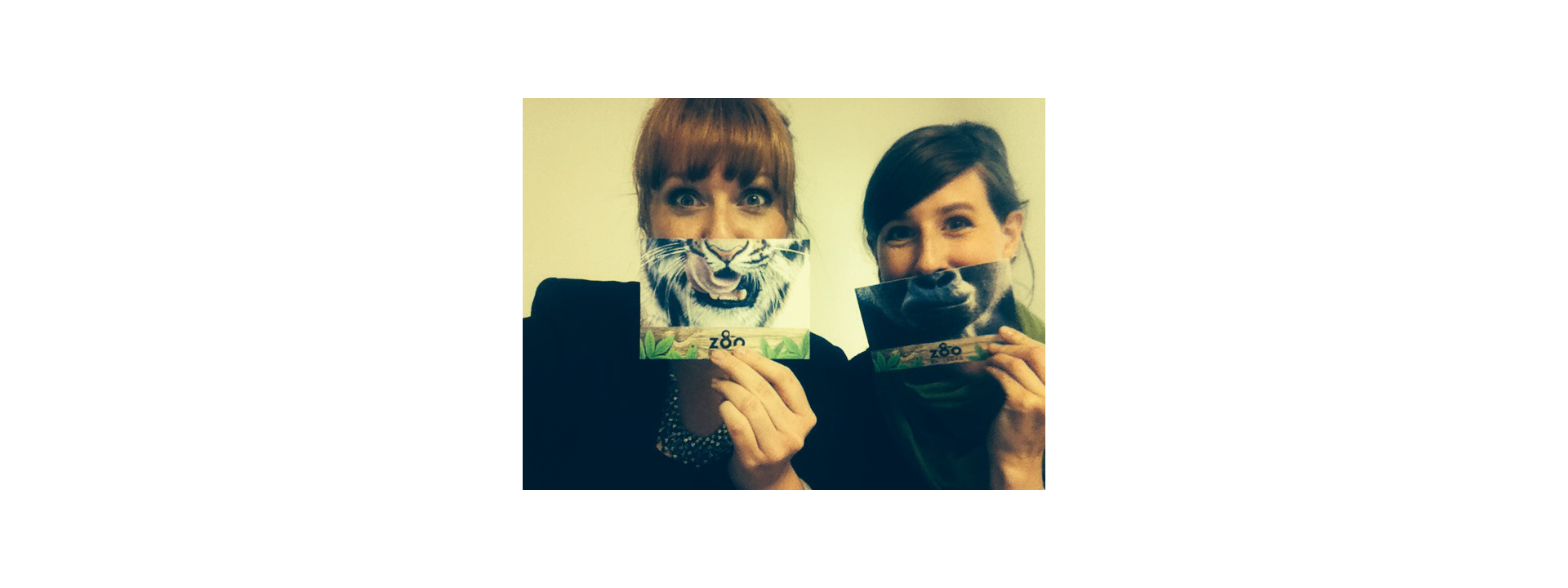 Zoo Duisburg Postkartenaktion zum 80-jährigen Jubiläum mit Tiermotiven, gehalten von zwei Personen.